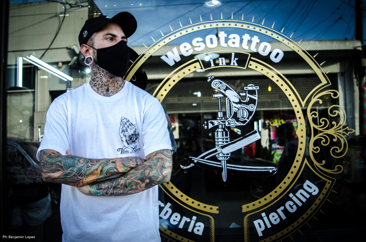 Tatuadora en acción aplicando técnica de sombreado y mandala